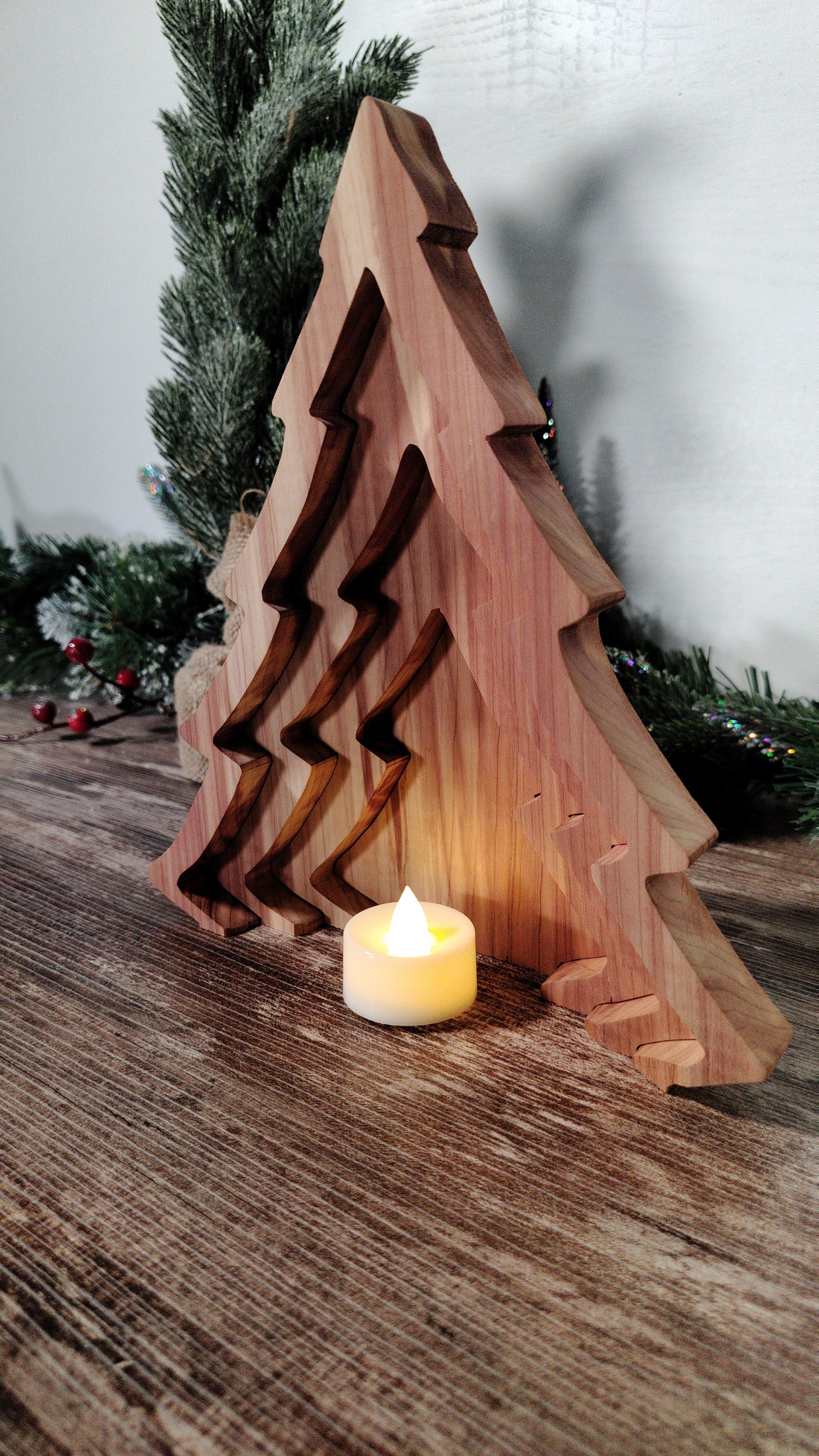 Wooden Christmas tree decoration with a candle on a wooden surface