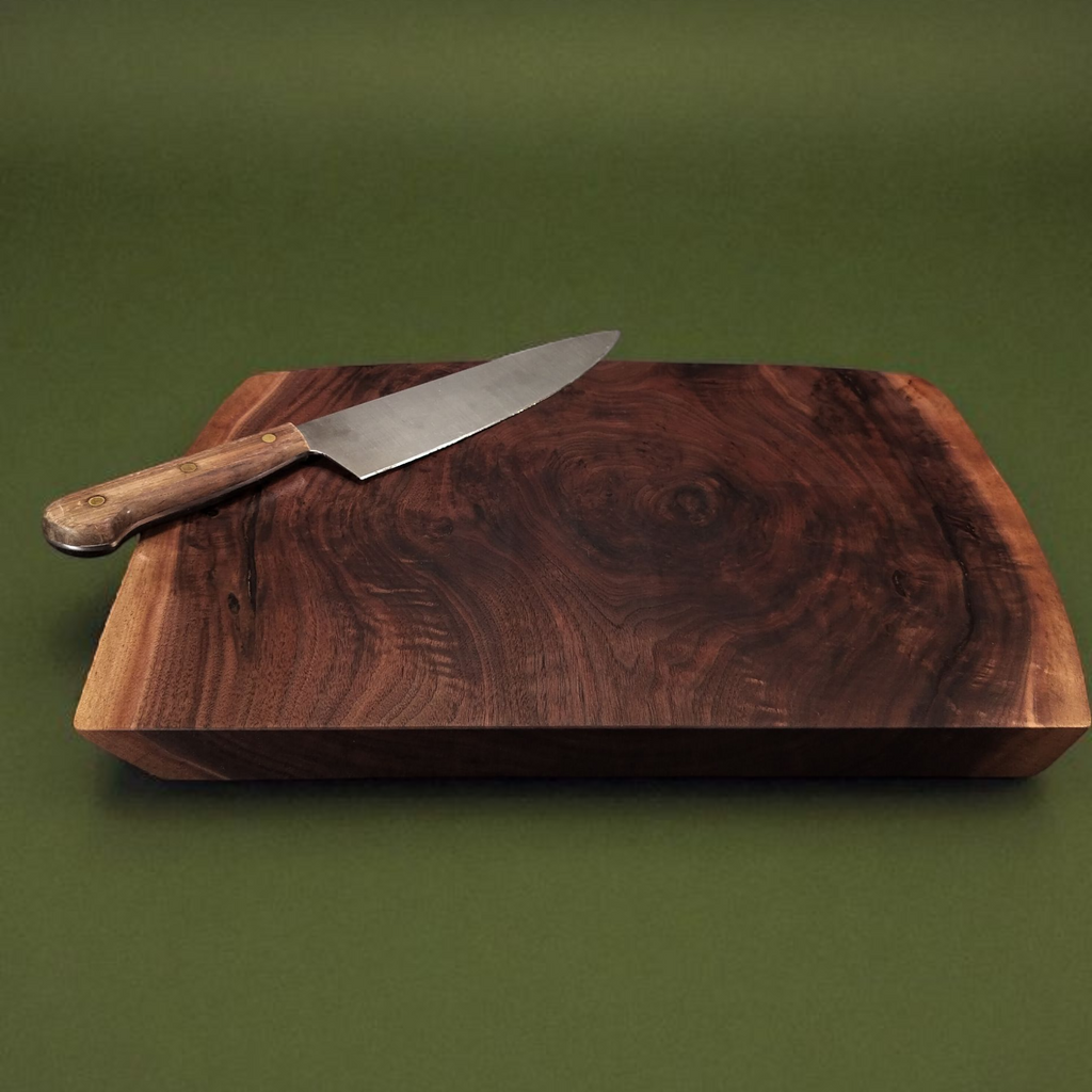 Wooden cutting board with a knife on a green background
